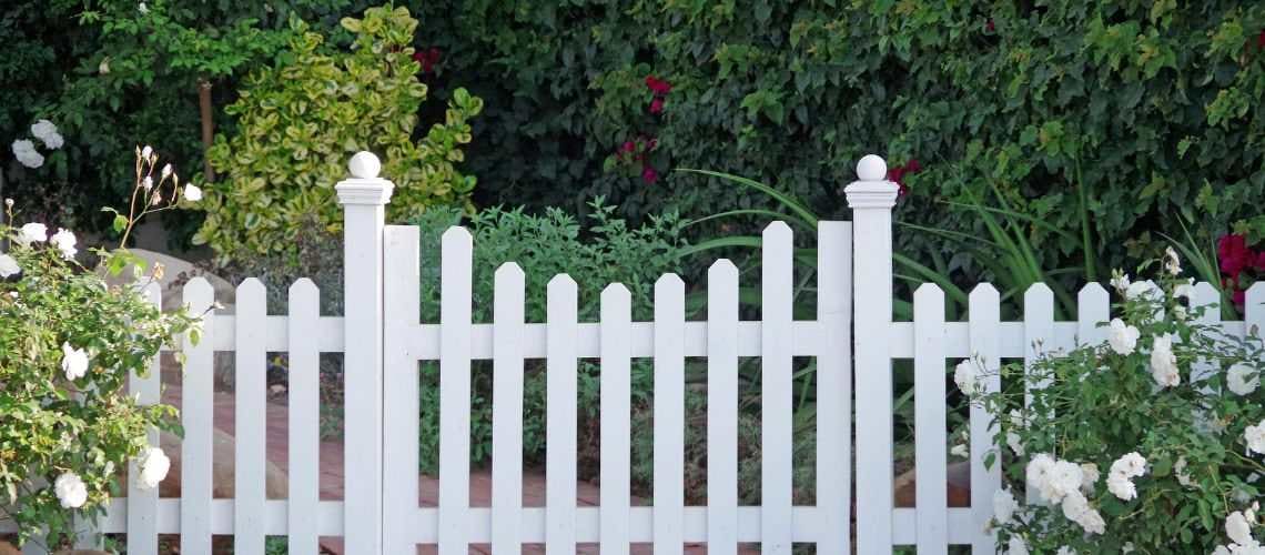 A white picket fence and matching garden gate