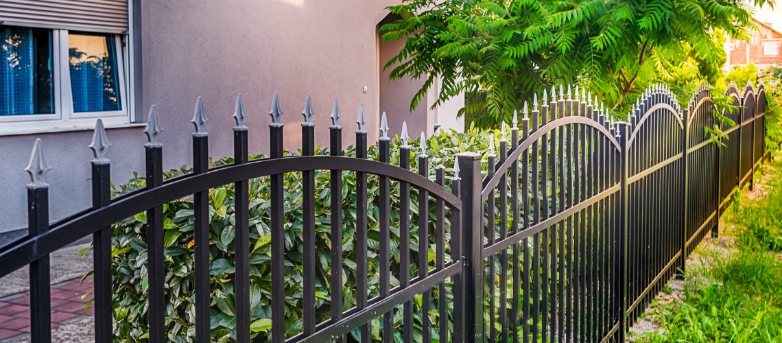 A black wrought iron fence with decorative spear-top pickets