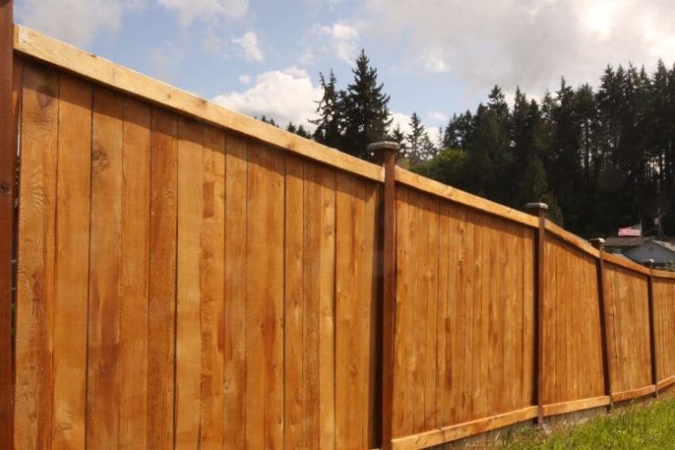 blog image 7 A long wooden privacy fence stretching along a grassy slope